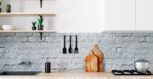 a clean kitchen counter with a brick backsplash in gray